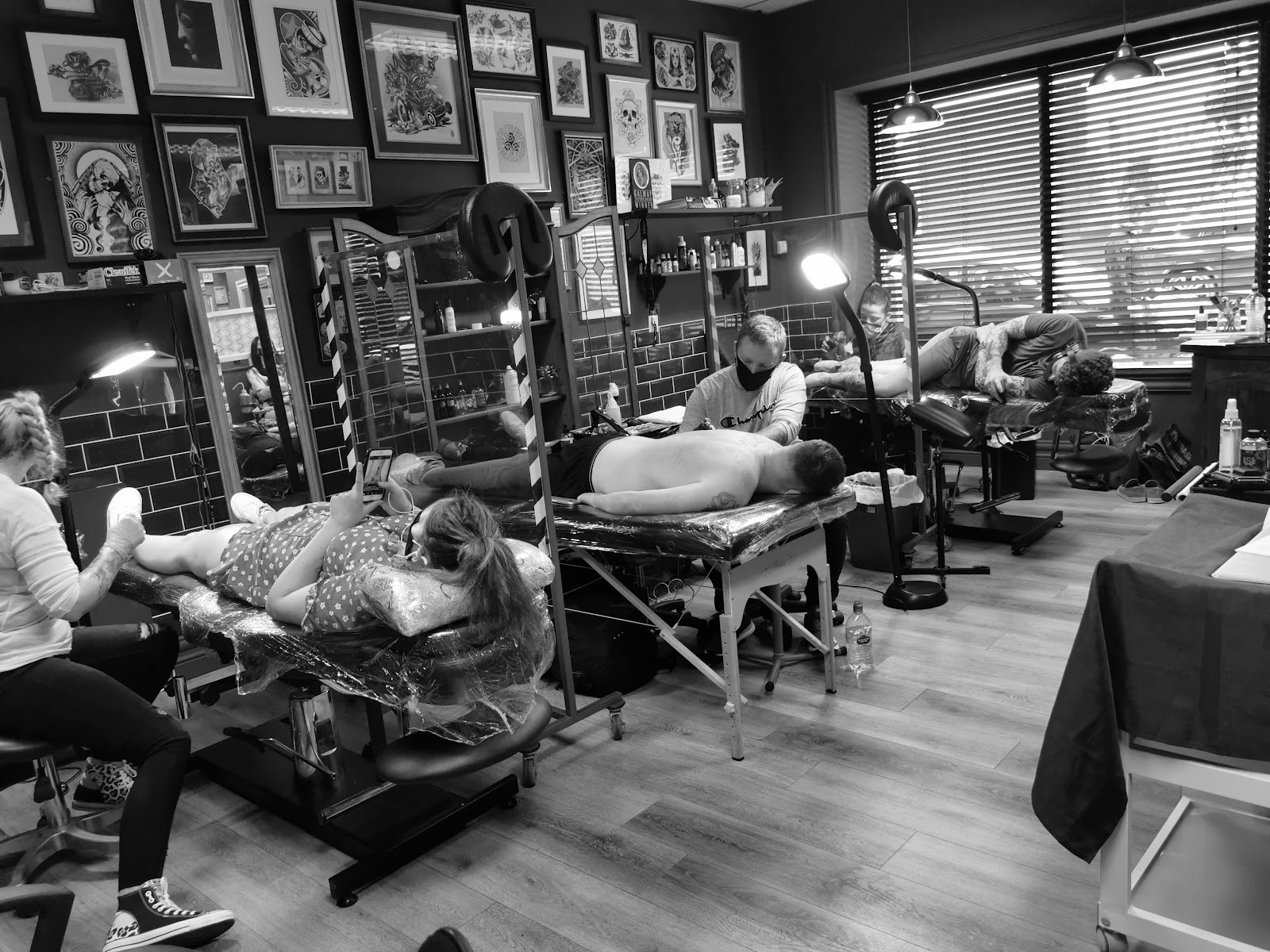 Workstations inside Soul Addiction Tattoo Studio, Limerick — tattoo beds, lamps and a wall of framed flash